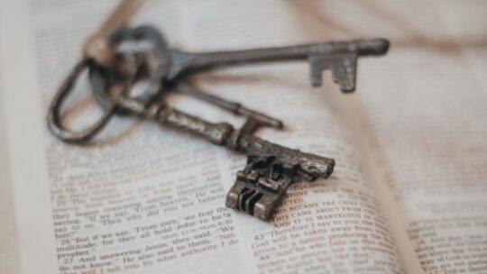 silver skeleton key on book page